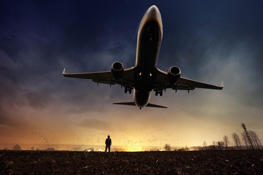 Avion qui décolle la nuit avec une personne qui regarde.