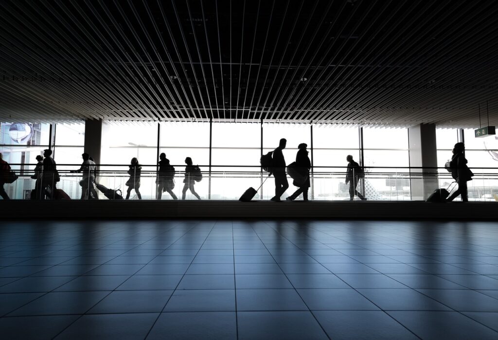 Hall d'aéroport avec des passagers et leurs valises.